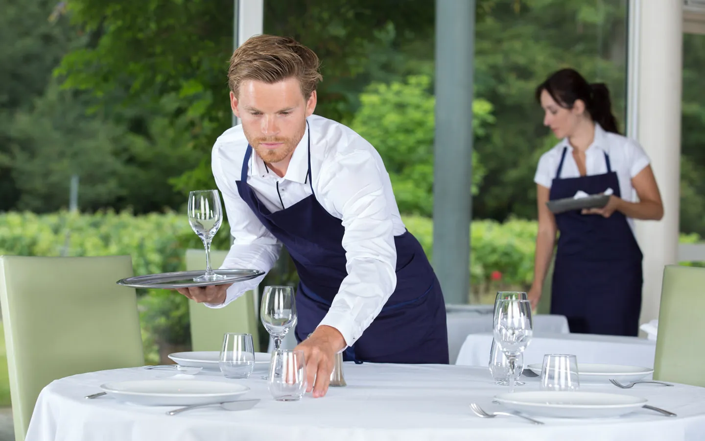 Restaurant staff setting a table in a fresh, odour-free dining room — AQOZA